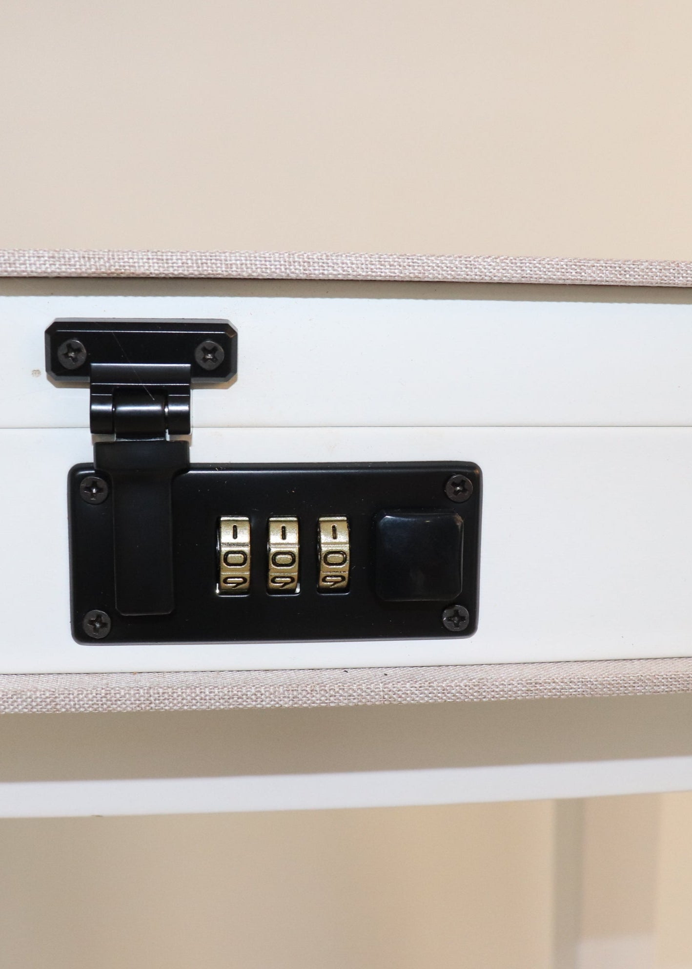 Close-up of a side of beige book box with a black combination lock 